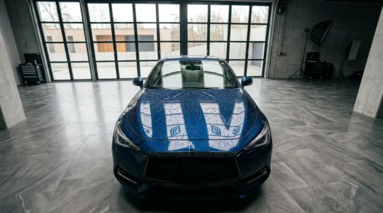 Film de protection PPF transparent appliqué sur le capot d'une voiture premium avec effet hydrophobe visible et brillance renforcée