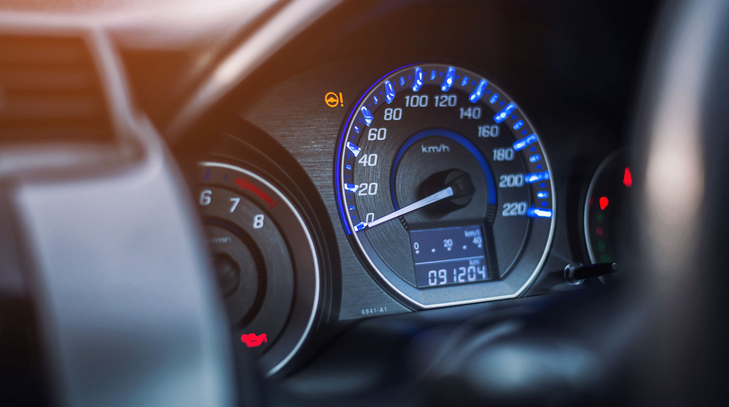 Gros plan sur un compteur kilométrique digital affichant 6420 km dans un habitacle de voiture moderne avec tableau de bord flouté en arrière-plan