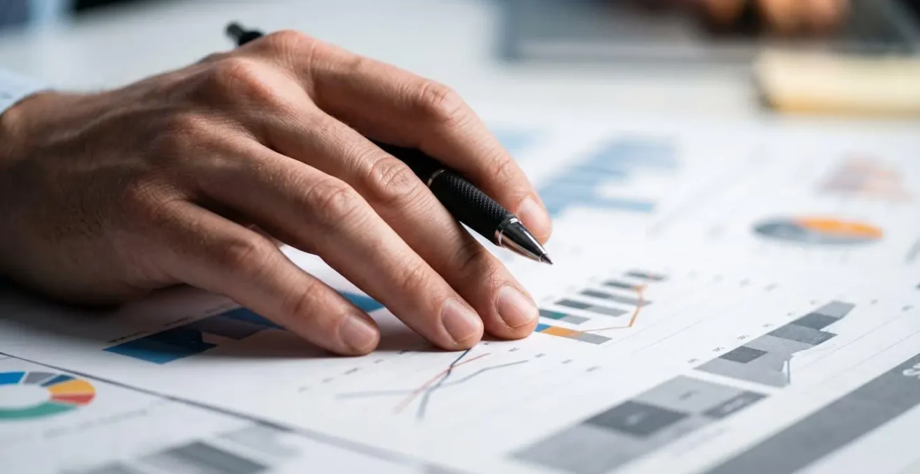 Main analysant des graphiques de valorisation automobile sur bureau épuré